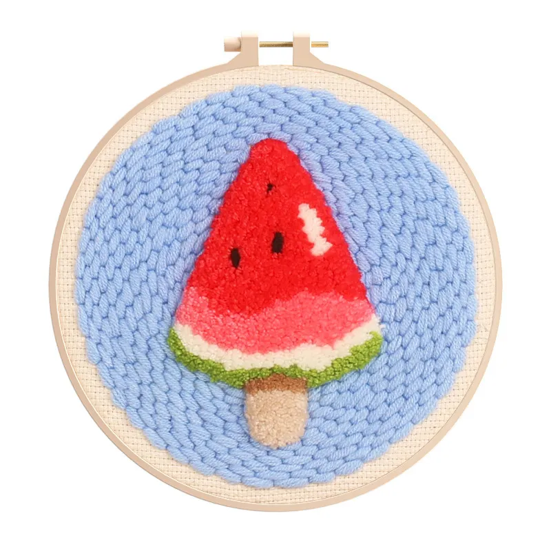 Tufted watermelon slice embroidery in hoop on blue knitted background