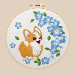 Handmade embroidery of a smiling Corgi surrounded by blue flowers, a delightful tribute to cute pets and a perfect gift for dog lovers.