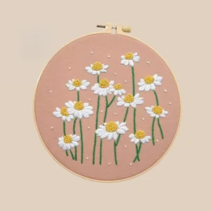 Hand embroidered flowers featuring white daisies with yellow centers and green stems on a pink background, perfect for gifts and floral wall decoration.
