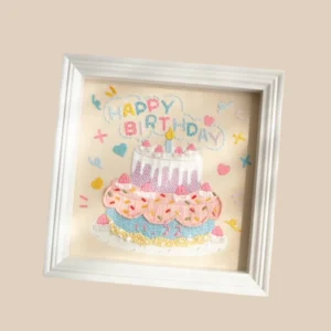 Hand-embroidered birthday cake artwork in a frame, ideal for unique birthday gift ideas